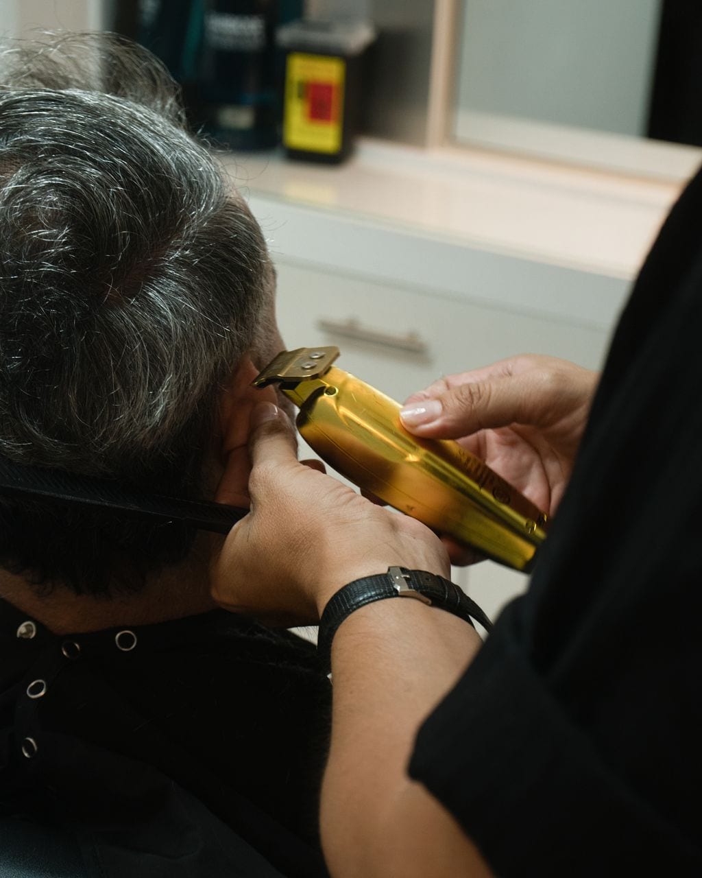 Gold clipper working around a client's ear